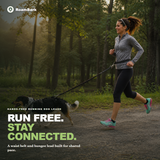 Runner on a forest trail with the waist belt fastened and the bungee leash running out to her dog.