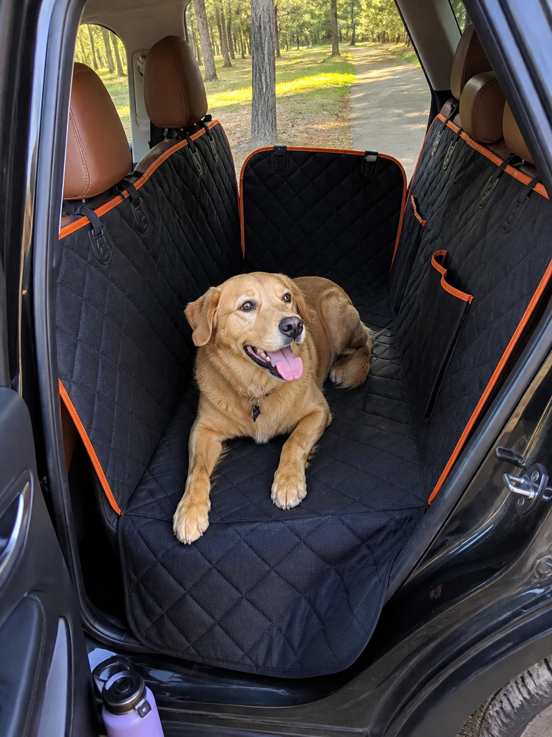 Dog resting on the Roam Bark back-seat hammock during a car journey